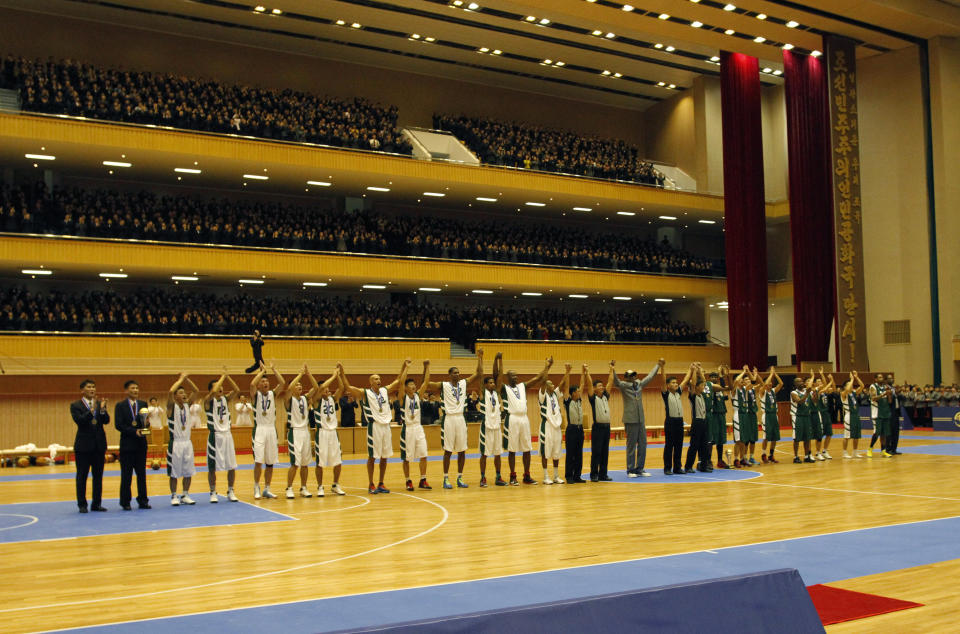 U.S. and North Korean basketball players raise their hands to the crowd after an exhibition game held at an indoor stadium in Pyongyang, North Korea on Wednesday, Jan. 8, 2014. Former NBA star Dennis Rodman came to the North Korean capital with a team of U.S. basketball stars for an exhibition game on the birthday of North Korean leader Kim Jong Un. (AP Photo/Kim Kwang Hyon)