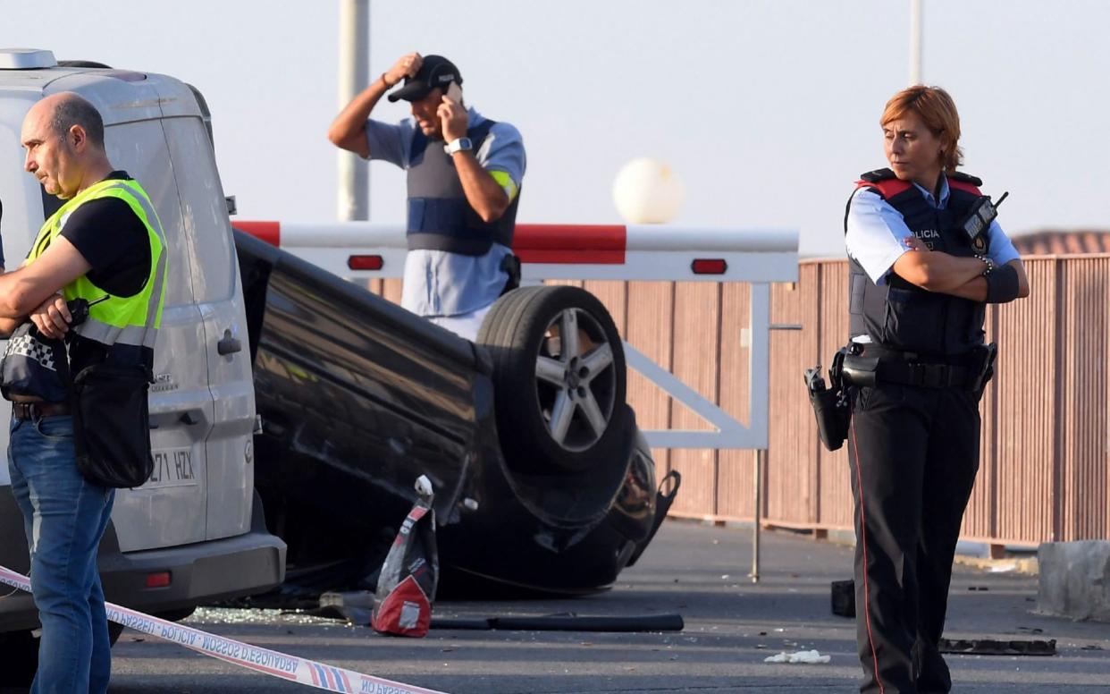 A policeman stands by a car involved in a terrorist attack in Cambrils, 120 kilometers south of Barcelona - AFP