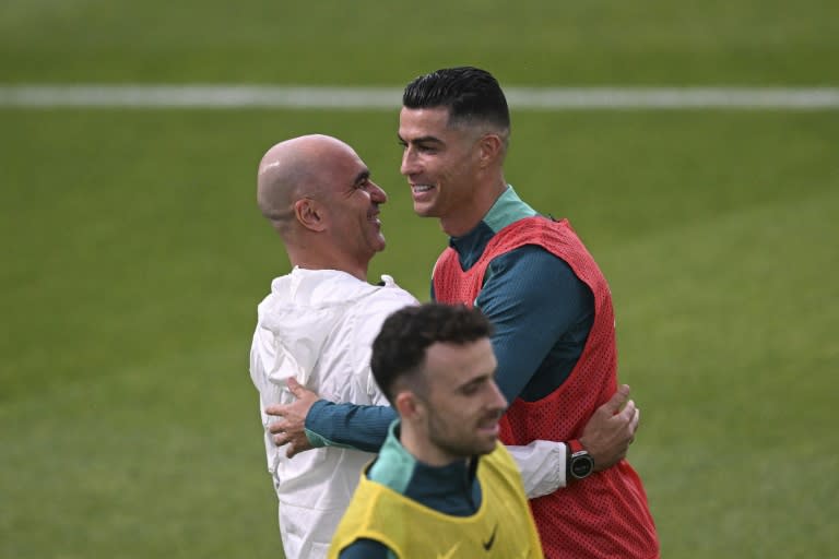 Cristiano Ronaldo et le sélectionneur portugais Roberto Martinez se prennent dans les bras lors d'un entraînement à la "Cidade do Futebol" à Oeiras près de Lisbonne au Portugal le 7 juin 2024 (PATRICIA DE MELO MOREIRA)