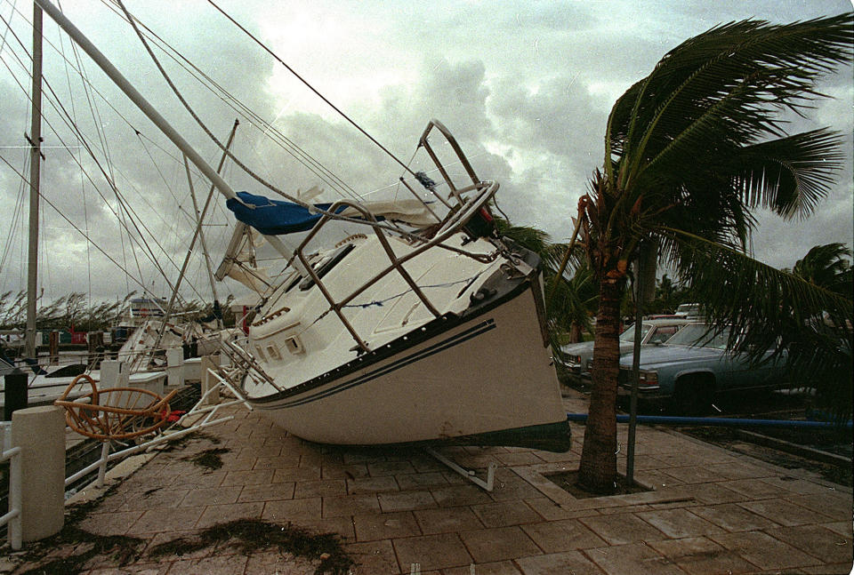 <p>In this Aug. 24, 1992 file photo, a sailboat sits on a sidewalk at Dinner Key in Miami after it was washed ashore by Hurricane Andrew. Several days after it almost dissipated, Andrew rapidly strengthened and was a Category 5 storm at landfall in Homestead, Fla. The Hurricane Center measured a peak wind gust of 164 mph. Andrew continued into the Gulf of Mexico before reaching the central Louisiana coast as a Category 3 hurricane. Andrew was blamed for 23 deaths in the U.S. and three deaths in the Bahamas and caused an estimated $26.5 billion in damage in the United States. (AP Photo/Terry Renna, File) </p>