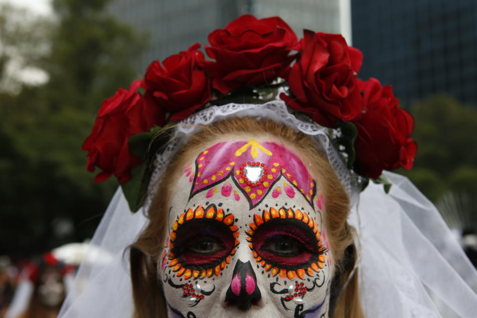 People dressed as Catrinas parade down Mexico City's iconic Reforma avenue during celebrations for the Day of the Dead in Mexico, Saturday, Oct. 26, 2019. (AP Photo/Ginnette Riquelme)