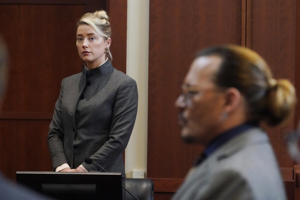 ARCHIVO - Los actores Amber Heard y Johnny Depp mientras el jurado sale de la sala para almorzar en el Tribunal de Circuito del Condado de Fairfax, en Fairfax, Virginia, el 16 de mayo de 2022. Un nuevo documento judicial presentado el viernes 8 de julio de 2022 por el equipo legal de Heard alega que uno de los miembros del jurado en el caso de difamación presentado en su contra por Depp, su exmarido, sirvió en el juicio indebidamente. (Foto AP/Steve Helber, Pool, archivo)