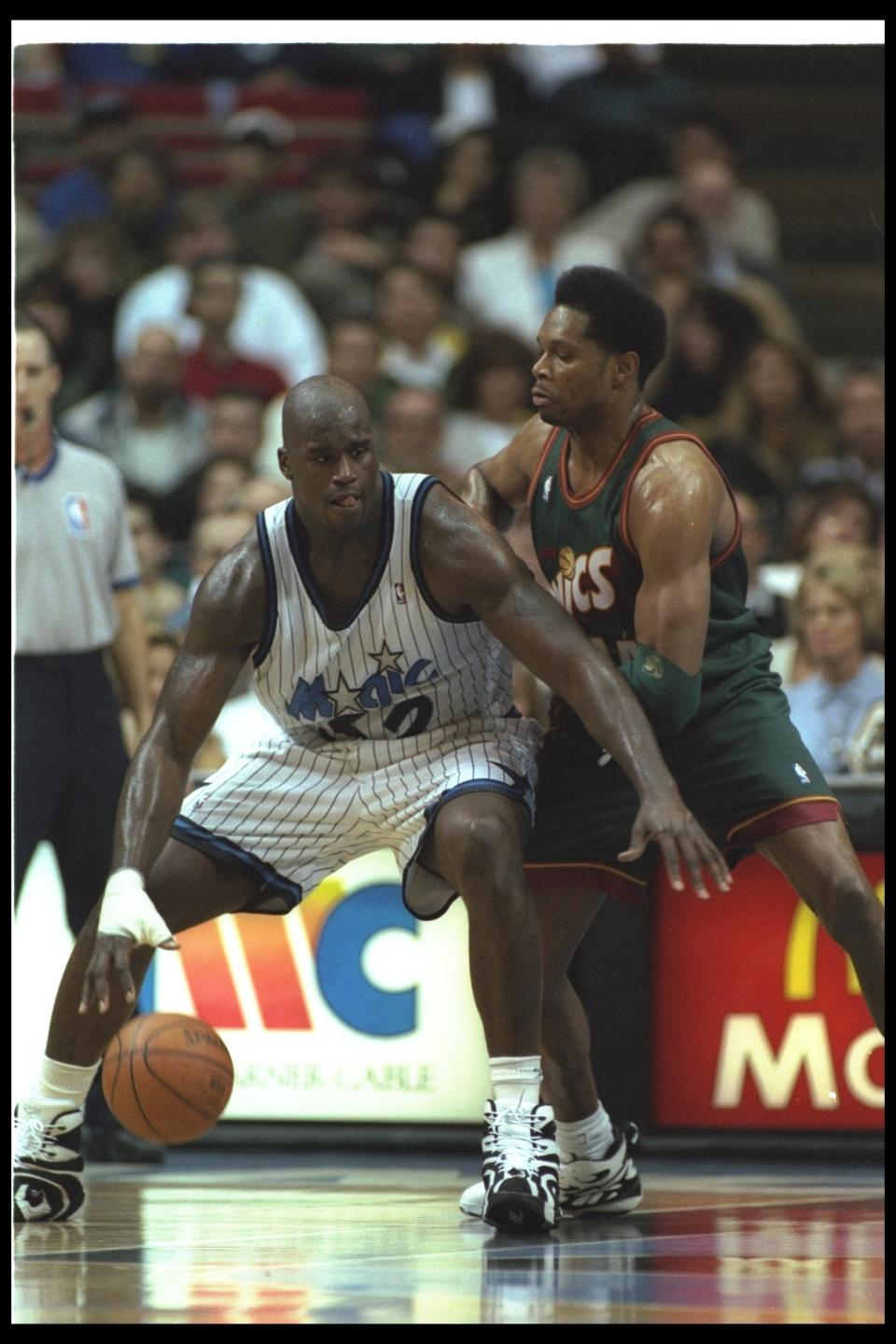 Shaquille O'Neal backs into center Sam Perkins of the Seattle SuperSonics during a game against the Seattle SuperSonics at the Orlando Arena in Orlando, Florida on January 5, 1995.