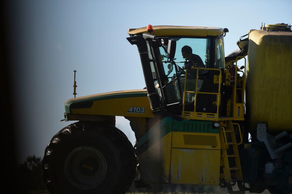 A tractor pulling a tank full of soil amendment sprays the ground at a farm near Warren County, Ga., on Jan. 26, 2023.