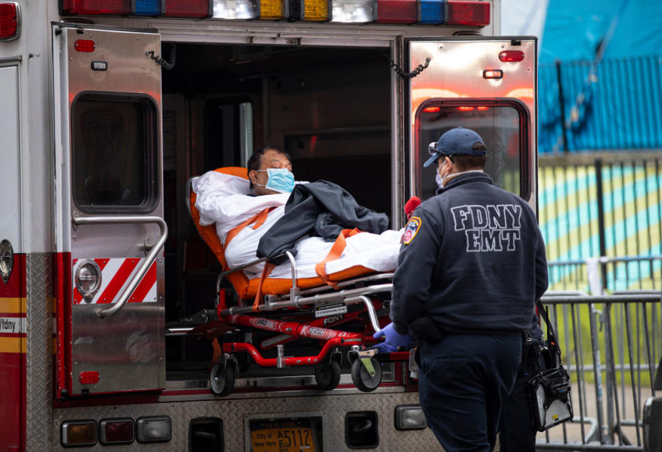 Two members of the Fire Department of New York Emergency Medical Team wheel in a patient with potentially fatal coronavirus to the Elmhurst Hospital Center in the Queens borough of New York City.