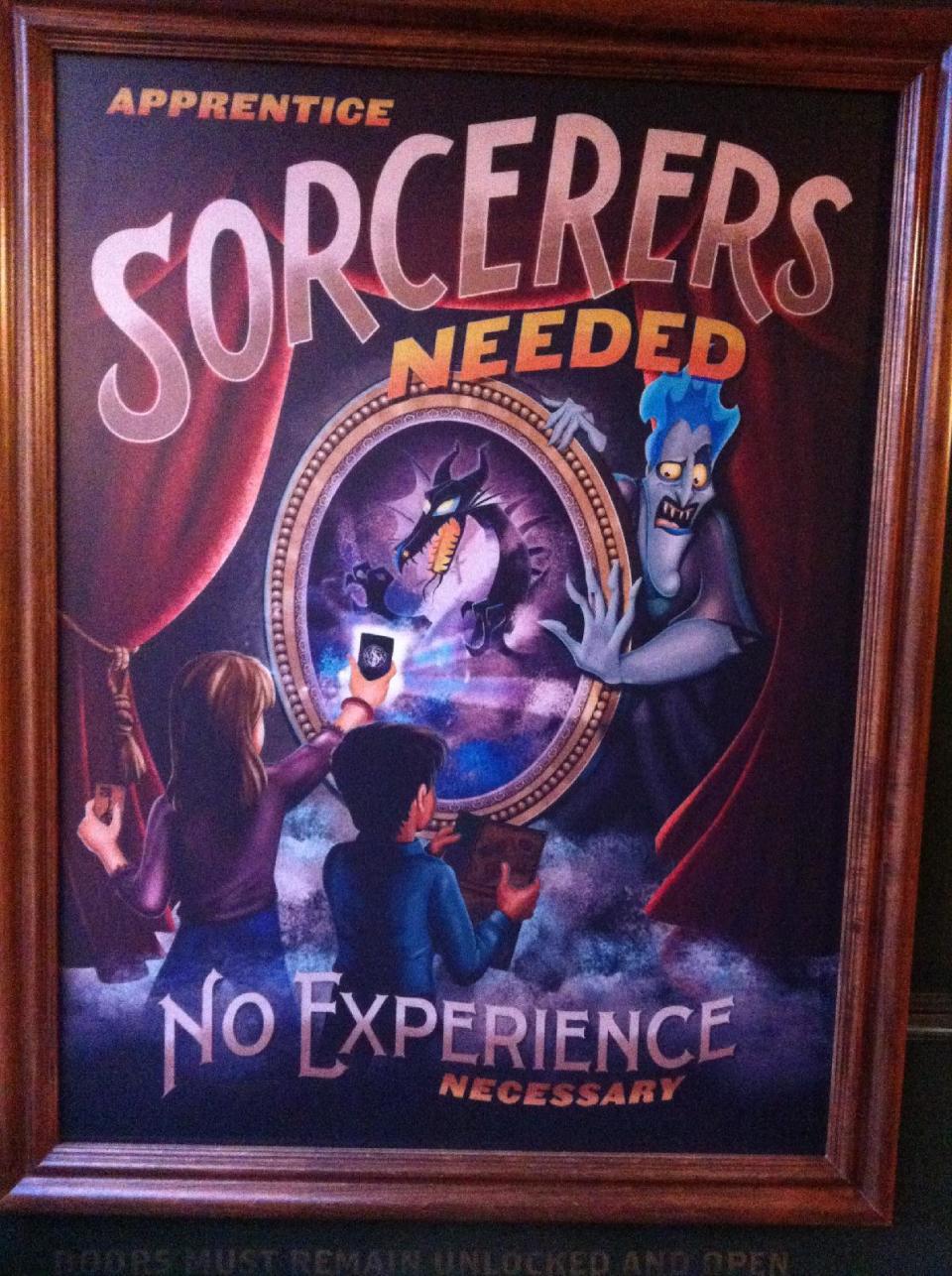 In this Feb. 15, 2013 photo, a sign encouraging Walt Disney World guests to participate in the "Sorcerers of the Magic Kingdom" game is displayed at the Magic Kingdom theme park in Lake Buena Vista, Fla. The "Sorcerers" game and others like it represent a recent push by Disney World to provide its guests with attractions that allow them to interact with their favorite characters. (AP Photo/Mike Householder)