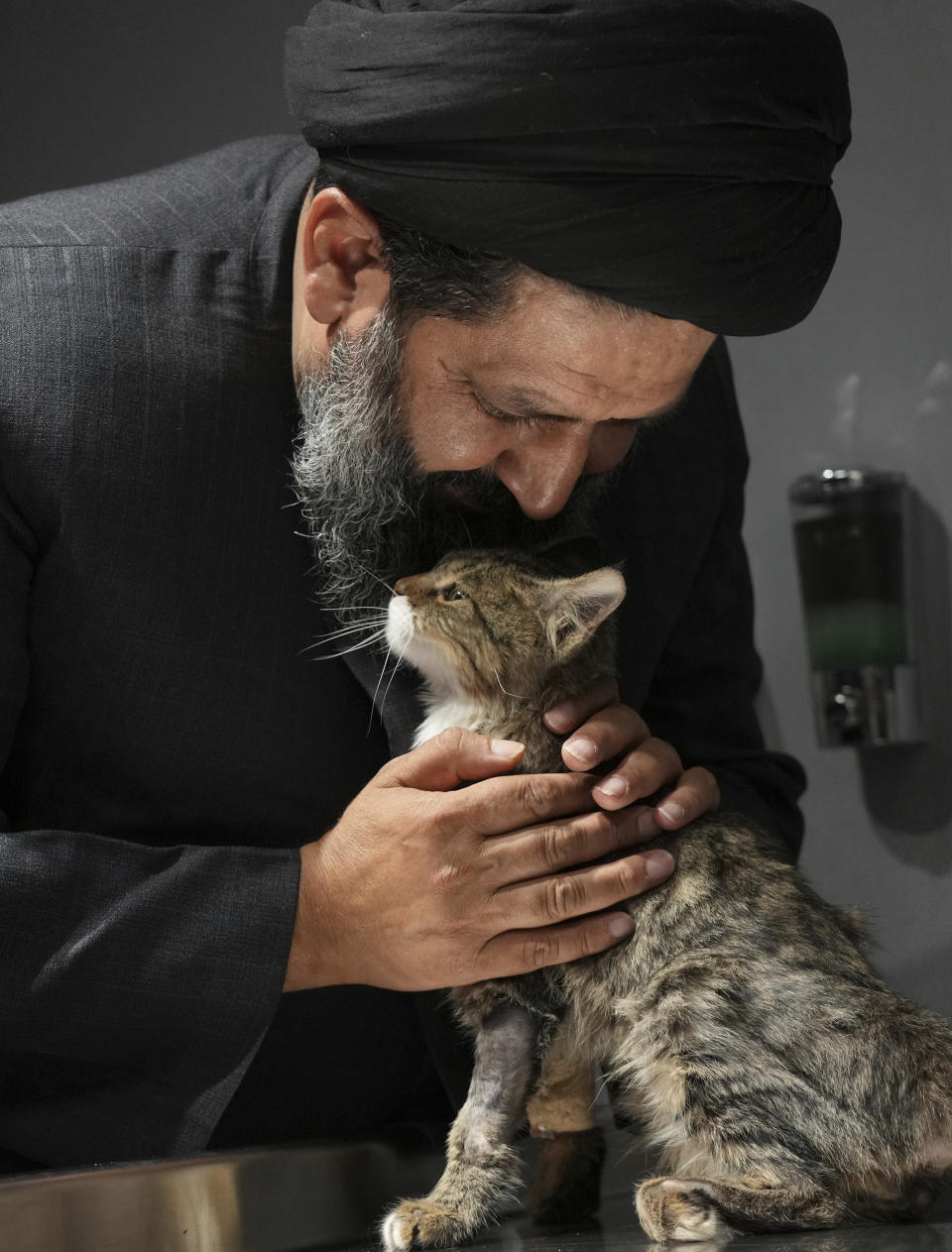 Iranian cleric Sayed Mahdi Tabatabaei kisses an injured stray cat after treatment at a veterinary clinic in Tehran, Iran, Friday, May 19, 2023. It's rare these days for a turbaned cleric in Iran to attract a large following of adoring young fans on Instagram, but Tabatabaei has done it by rescuing street dogs in defiance of a local taboo. (AP Photo/Vahid Salemi)