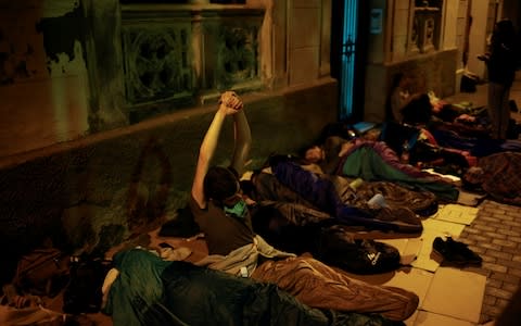 People sleep outside a polling station for the banned independence referendum in Barcelona - Credit: Reuters