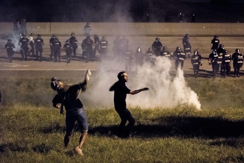 Protesters throw objects at police officers.