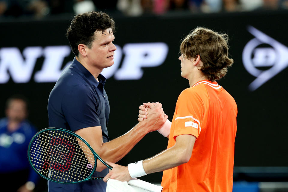 Milos Raonic and Alex de Minaur embrace.