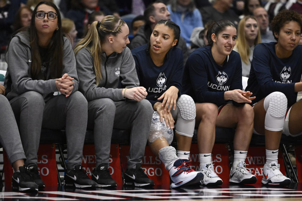 UConn's Paige Bueckers, second from left, talks with teammate Azzi Fudd in the second half of an NCAA college basketball game, Sunday, Jan. 15, 2023, in Hartford, Conn. Fudd left the game in the first half with an injury to her knee and did not return. (AP Photo/Jessica Hill)