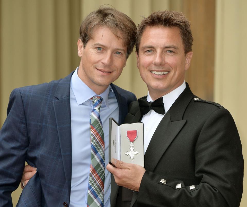<p>Barrowman with his husband, Scott Gill, after being awarded an MBE at Buckingham Palace, October 2014</p>Getty
