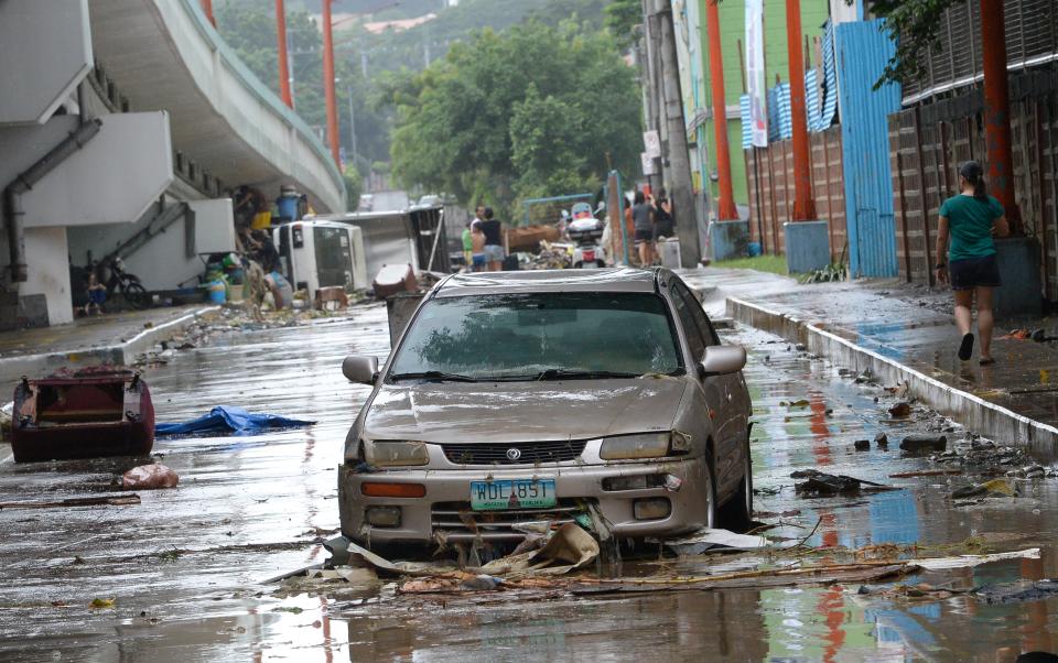 A resident walks past washed up vehicles on a road after flooding brought about by heavy downpour due to exiting Tropical storm Yagi, submerged homes in Marikina City, the Philippines. (Photo: Getty Images)