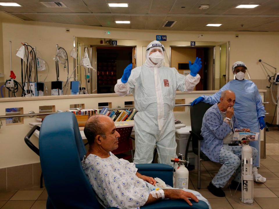 Medical staff workers at Tel Aviv’s Sourasky hospital, one of hundreds of vaccination centres, bid a special farewell to a Covid patient who recovered (AFP via Getty Images)