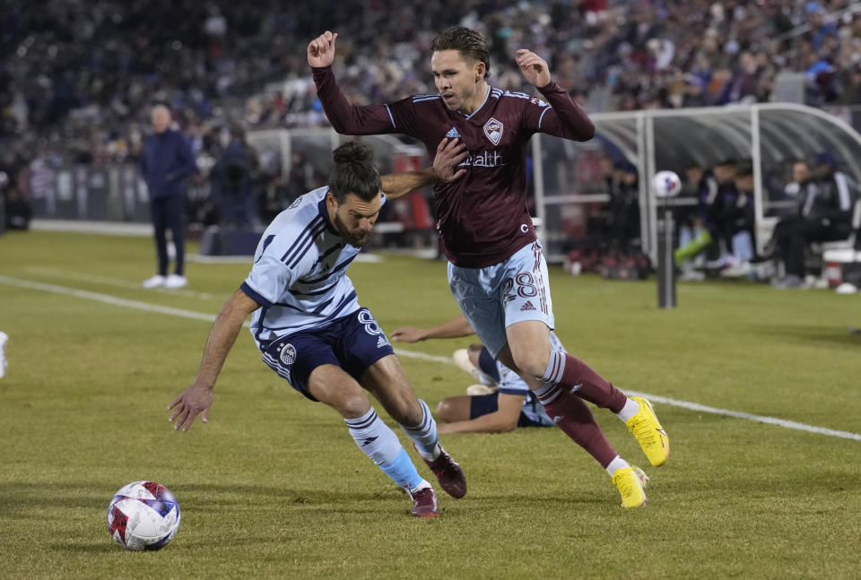 Sporting Kansas City midfielder Graham Zusi, left, blocks Colorado Rapids midfielder Sam Nicholson as he tries to collect the ball during the first half of an MLS soccer match Saturday, March 4, 2023, in Commerce City, Colo. (AP Photo/David Zalubowski)