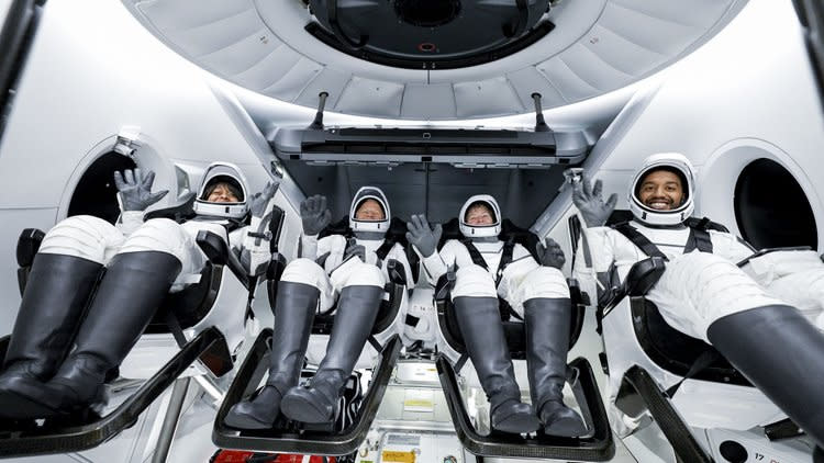 Four Ax-2 Axiom Space astronauts wave to recovery teams after the hatch to their Dragon spacecraft is opened following splashdown