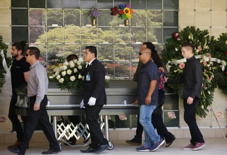 Relatives and friends wheel the casket of elementary school teacher Elsa Mendoza, who was killed during the shooting at a Walmart store in El Paso, Texas, U.S., last Saturday, after her wake at a funeral parlor in Ciudad Juarez