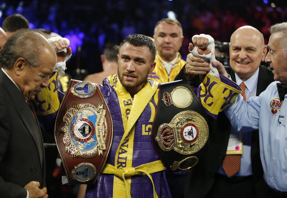 FILE - In this April 12, 2019, file photo, Vasiliy Lomachenko celebrates defending his WBA/WBO lightweight titles after knocking out Anthony Crolla, in Los Angeles. Lomachenko fights Teofimo Lopez on Saturday, Oct. 17, 2020, in Las Vegas. Boxing fans should be thankful. They’re getting a quality fight _ and they’re getting it for free.(AP Photo/Damian Dovarganes, File)