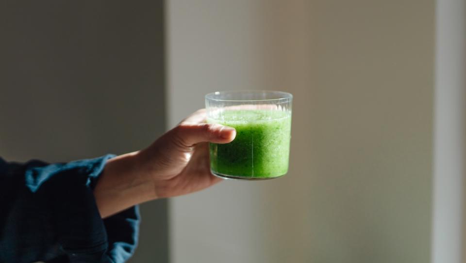 Person holding a green smoothie
