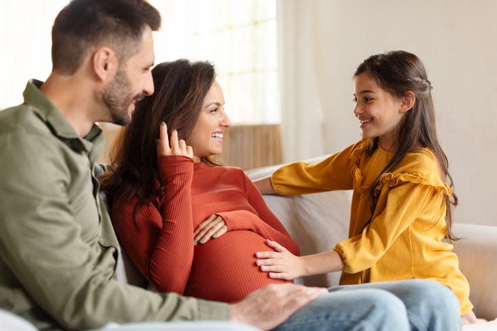 Second Pregnancy. Daughter Touching Pregnant Mother's Belly Waiting For Little Brother.