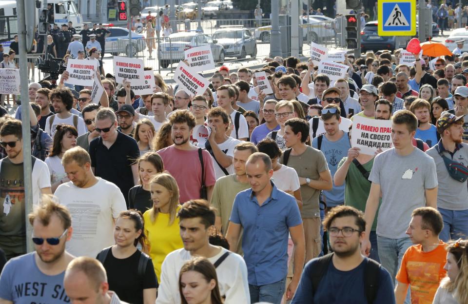 Protesters hold posters that read: "I have the right to my candidate" during an unsanctioned rally in the center of Moscow, Russia, Saturday, July 27, 2019. Russian police are wrestling with demonstrators and have arrested hundreds in central Moscow during a protest demanding that opposition candidates be allowed to run for the Moscow city council. (AP Photo/Alexander Zemlianichenko)