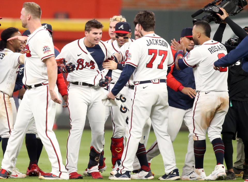Austin Riley celebrates his walk off RBI with his teammates in Game 1 of the NLCS.