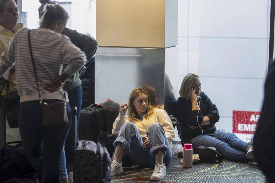 Passengers wait in departure lounges at Auckland Airport after flights were canceled and passengers stranded as a cyclone hit the northern parts of New Zealand, Sunday, Feb. 12, 2023. New Zealand's national carrier has canceled dozens of flights as Aucklanders brace for a deluge from Cyclone Gabrielle, two weeks after a record-breaking storm swamped the nation's largest city and killed several people. (George Heard/NZ Herald via AP)