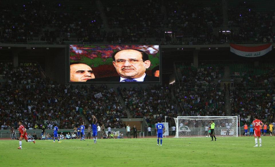 FILE - In this file photo taken on Oct. 12, 2013 Iraqi Prime Minister Nouri al-Maliki is shown on a screen as he attends the opening day of Sport City in Basra, Iraq. If Iraqi Prime Minister Nouri al-Maliki wins a third four-year term in parliamentary elections Wednesday, he is likely to rely on a narrow sectarian Shiite base, only fueling divisions as Iraq slides deeper into bloody Shiite-Sunni hatreds. (AP Photo/Nabil al-Jurani, File)