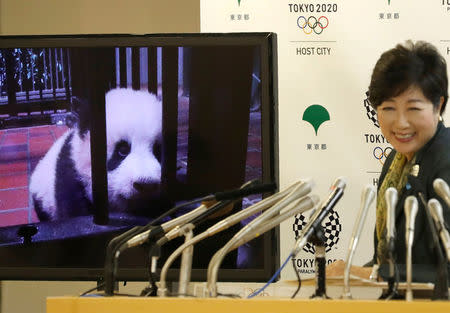 A panda cub named Xiang Xiang, born from mother panda Shin Shin at Tokyo's Ueno Zoological Gardens on June 12, 2017, is shown on a screen next to Tokyo Governor Yuriko Koike during a news conference to announce the name at Tokyo Metropolitan Government Building in Tokyo, Japan September 25, 2017. REUTERS/Kim Kyung-Hoon