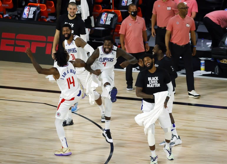 Members of the Los Angeles Clippers celebrate after breaking a team three-point record during an NBA basketball game against the New Orleans Pelicans, Saturday, Aug. 1, 2020, in Lake Buena Vista, Fla. (Kevin C. Cox/Pool Photo via AP)