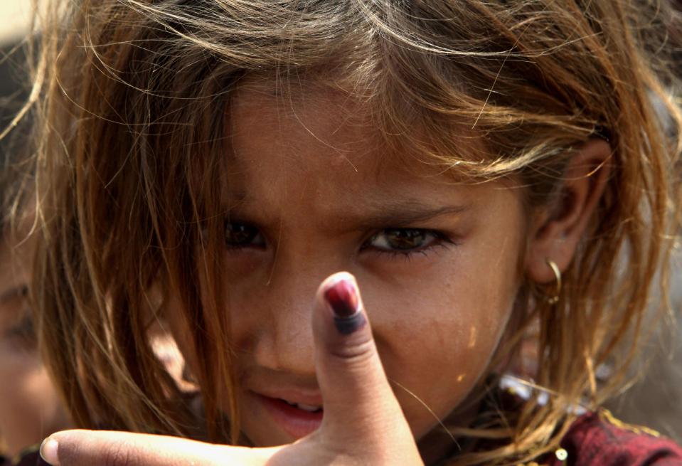 Pakistani girl Amina shows her thumb being marked after receiving polio vaccine in Lahore, Pakistan, Monday, May 5, 2014. For the first time ever, the World Health Organization on Monday declared the spread of polio an international public health emergency that could grow in the next few months and unravel the nearly three-decade effort to eradicate the crippling disease. (AP Photo/K.M. Chaudary)