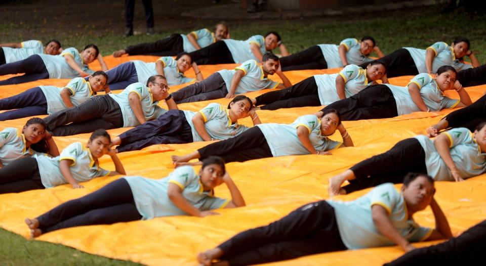 People perform yoga exercises during International Day of Yoga in Kolkata, India 21 June 2024 (EPA)