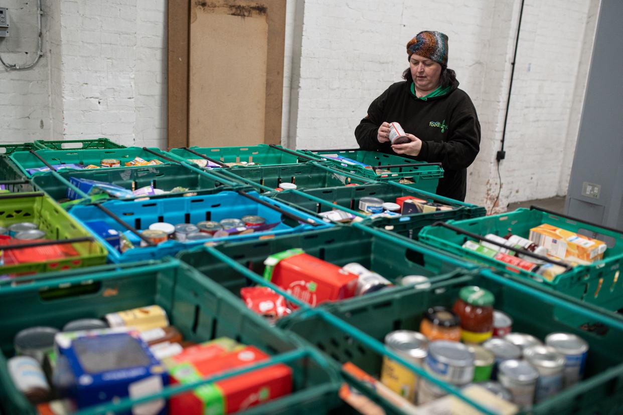 A member of staff at The Halo Centre, the central distribution point for donated items to be distributed to the Coventry Foodbank network of 14 sites across the city, checks food parcels that will be provided to people with a foodbank voucher, in Coventry, central England on January 23, 2023. - In Coventry, a city once home to a thriving car manufacturing industry, the 