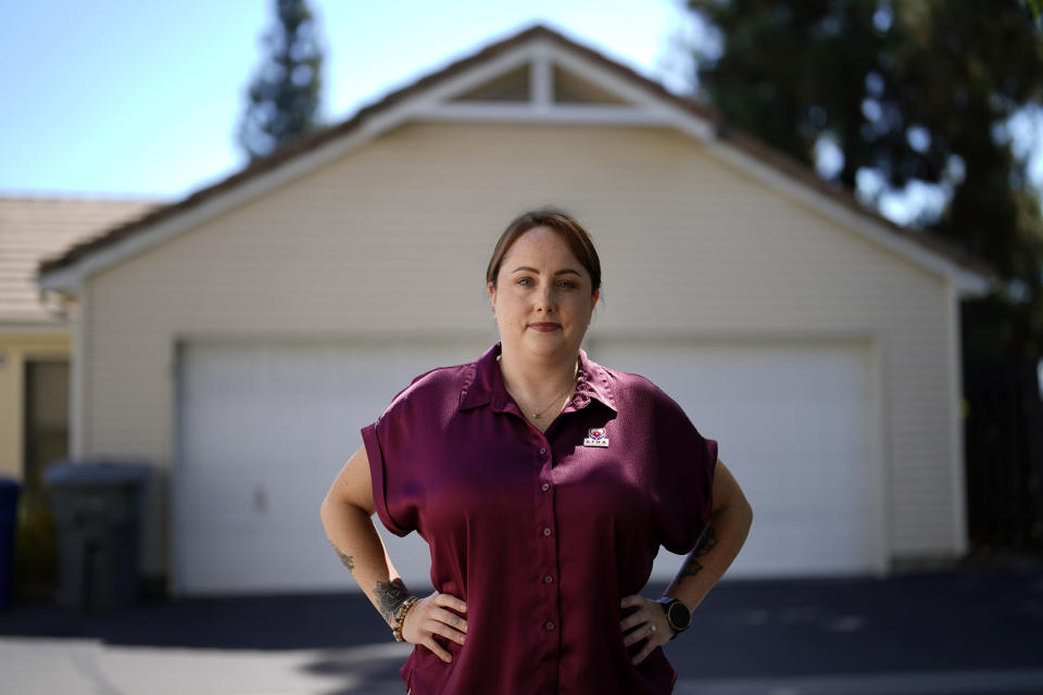 Kate Needham, a veteran who co-founded the nonprofit Armed Forces Housing Advocates, looks on in a housing complex, Tuesday, Aug. 16, 2022, in San Diego. Needham's group supplies microgrants to military families in need, some of whom have resorted to food banks because their salaries do not cover such basics. “I don’t think civilians really understand — they might think we’re living in free housing and just having a great time, making lots of money. And that’s not the case at all.” (AP Photo/Gregory Bull)