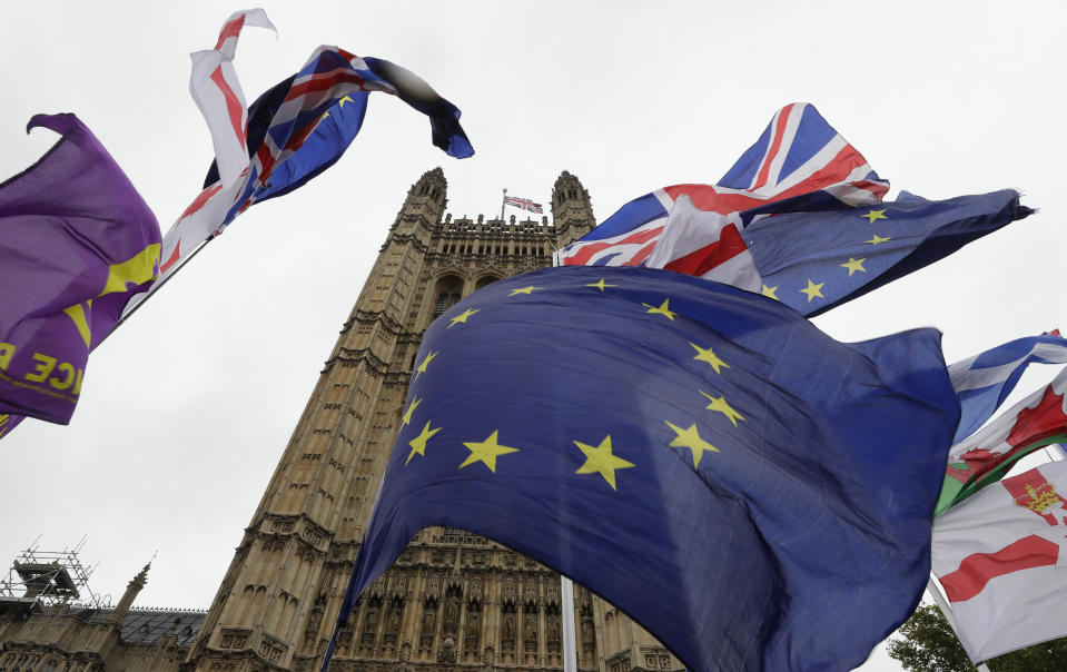 A confusion of various flags fly outside Parliament in London, Monday, Oct. 21, 2019. The European Commission says the fact that British Prime Minister Boris Johnson did not sign a letter requesting a three-month extension of the Brexit deadline has no impact on whether it is valid and that the European Union is considering the request. (AP Photo/Kirsty Wigglesworth)