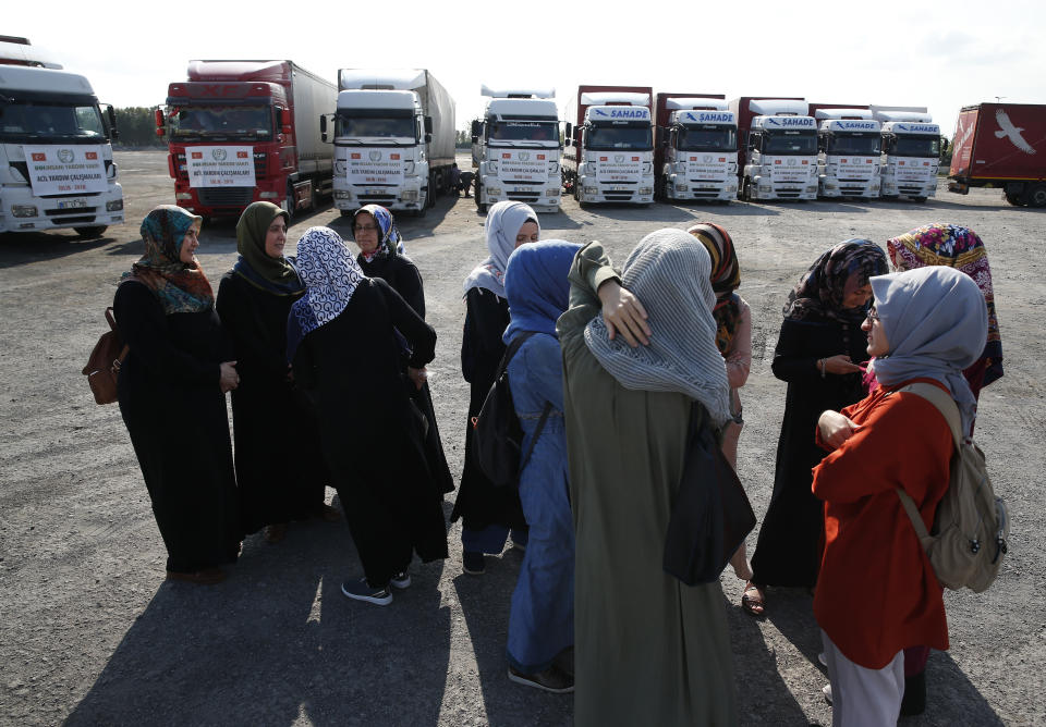 FILE - In this Sept. 10, 2018 file photo, members of a Turkish pro-government aid group, wait for the departure of trucks carrying humanitarian aid destined for Idlib, Syria, in Istanbul. Over the last two days, members of the UN Security Council have been haggling over cross-border aid delivery to Syria, with Russia, a major ally of the Syria government, working to reduce the delivery of U.N. humanitarian aid to Syria's last rebel-held northwest down from two crossings to just one. A final vote is expected Friday, July 10, 2020 as western countries push on a new resolution to keep the two crossings open for six months, instead of a year. (AP Photo/Lefteris Pitarakis, File)