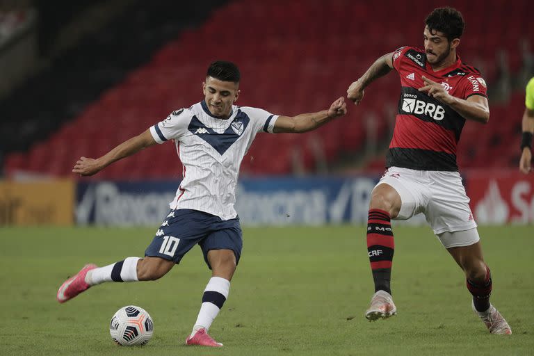 Thiago Almada, enganche de Vélez, remata al arco sin que el central Gustavo Henrique lo pueda evitar; un empate 0-0 con Flamengo que le impidió al equipo de Mauricio Pellegrino finalizar primero en su zona