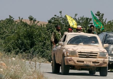 Hezbollah fighters ride in the back of a truck at Juroud Arsal, Syria-Lebanon border, July 25, 2017. REUTERS/Mohamed Azakir