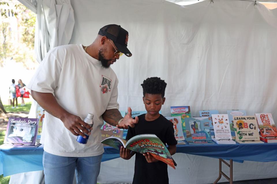 Richard Stokes and his son Karter Stokes, 8, in a booth at the Los Angeles Times Festival of Books.