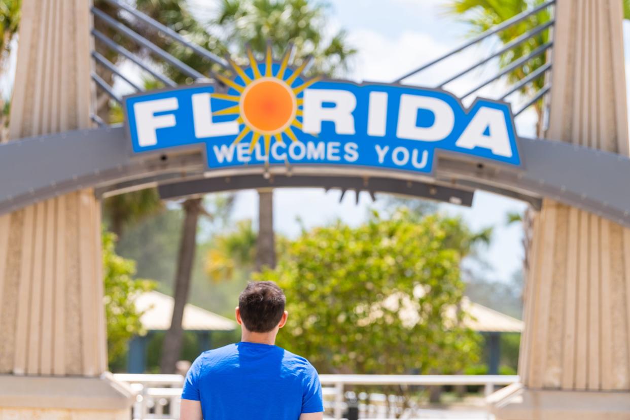 Florida welcome center at border with Alabama and visitor center and back of young man looking at sign