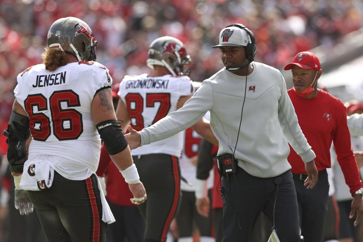 Tampa Bay Buccaneers offensive coordinator Byron Leftwich celebrates with center Ryan Jensen (66) after scoring against the Philadelphia Eagles in Sunday's playoff game.