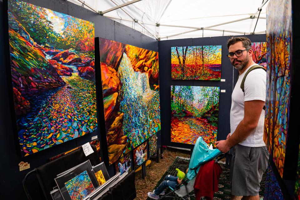 Oct 15, 2022; Northport, AL, USA; Frank Barker looks at work by Lydia Randolph during the Kentuck Festival of the Arts Saturday, Oct. 15, 2022.