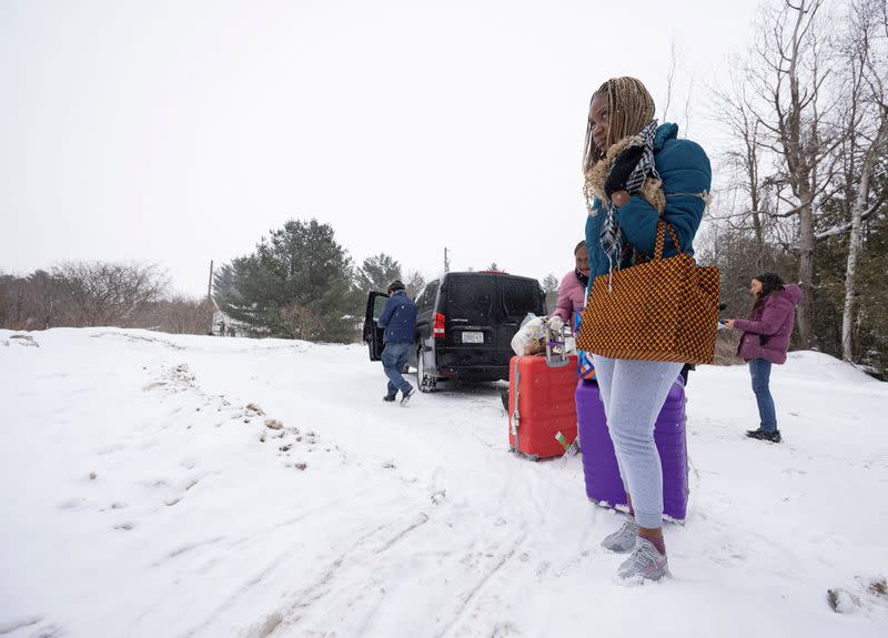 Asylum seekers cross into Canada from Roxham Road in Champlain New York
