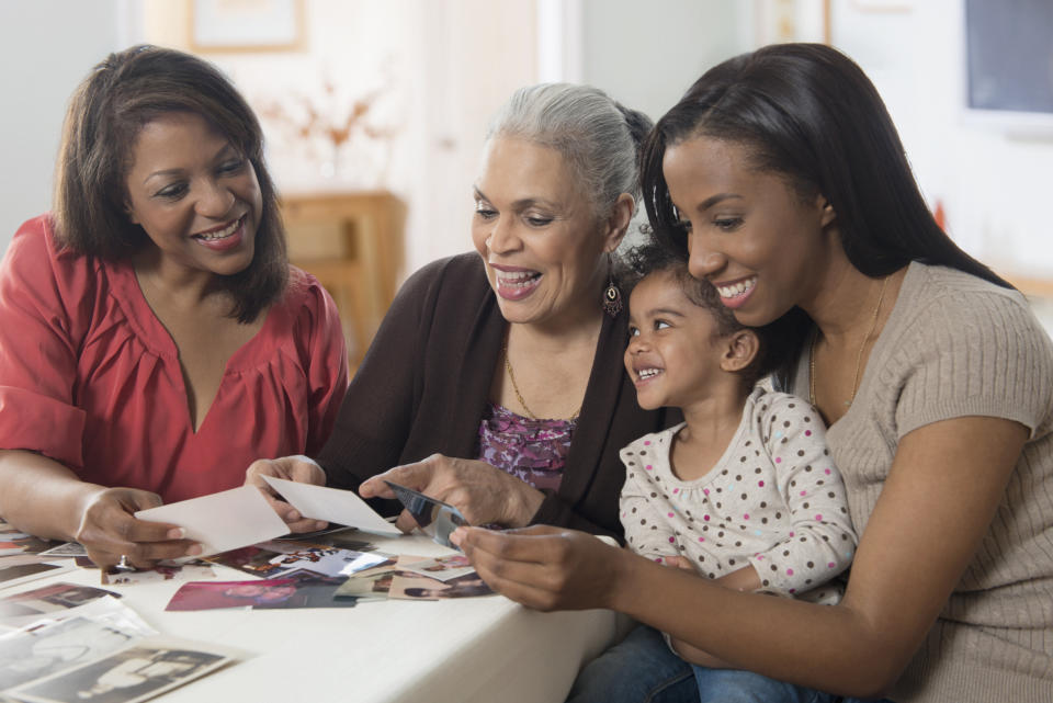 Three generations of women looking at photographs