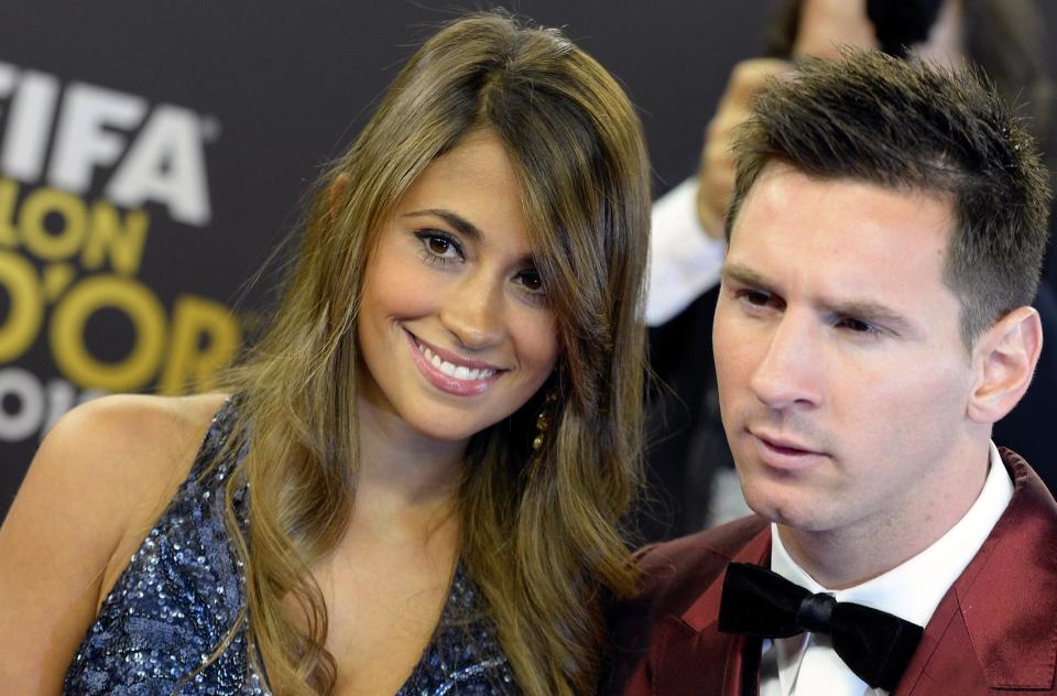 Soccer player Lionel Messi, right, of Argentina arrives with his wife Antonella, left, on the red carpet prior to the FIFA Ballon d'Or 2013 gala held at the Kongresshaus in Zurich, Switzerland, Monday, Jan. 13, 2014. (AP Photo/Keystone,Walter Bieri)