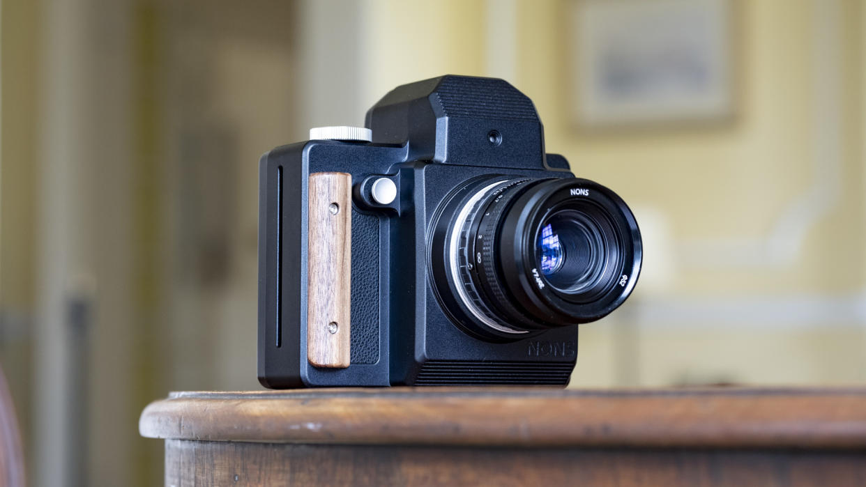  Nons SL660 instant camera on a mahogany table. 