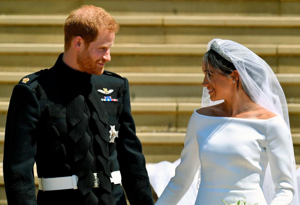 Prince Harry and Meghan Markle walk down the steps after their wedding at St. George's Chapel in Windsor Castle in Windsor, near London, England, Saturday, May 19, 2018.