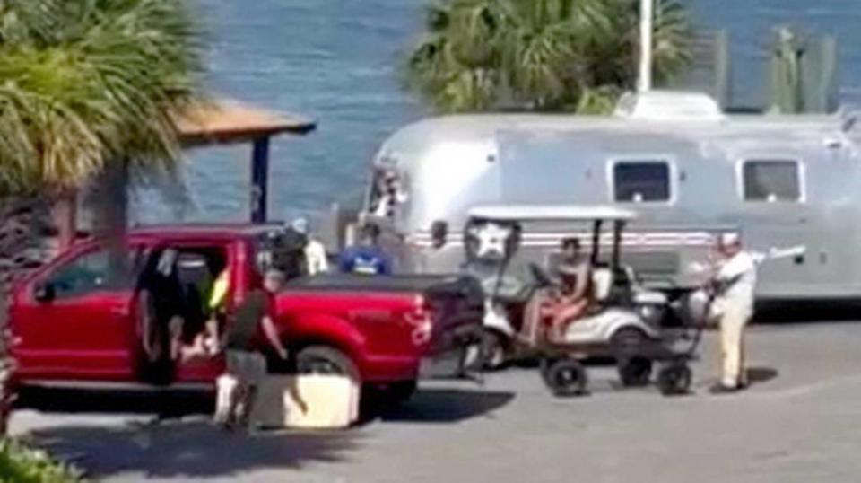 In this screen capture from a video, a person with an empty wagon, right, can be seen after it was used to transport an injured person on May 29, 2024, to a personal vehicle after a boating accident near Sea Monkeys Watersports at Hilton Head Harbor RV Resort Marina.