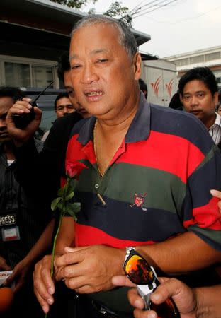 Democrat Party candidate and incumbent Bangkok Governor Sukhumbhand Paribatra holds a red rose as he arrives at the Democrat Party headquarters in Bangkok March 3, 2013. REUTERS/Chaiwat Subprasom/File Photo