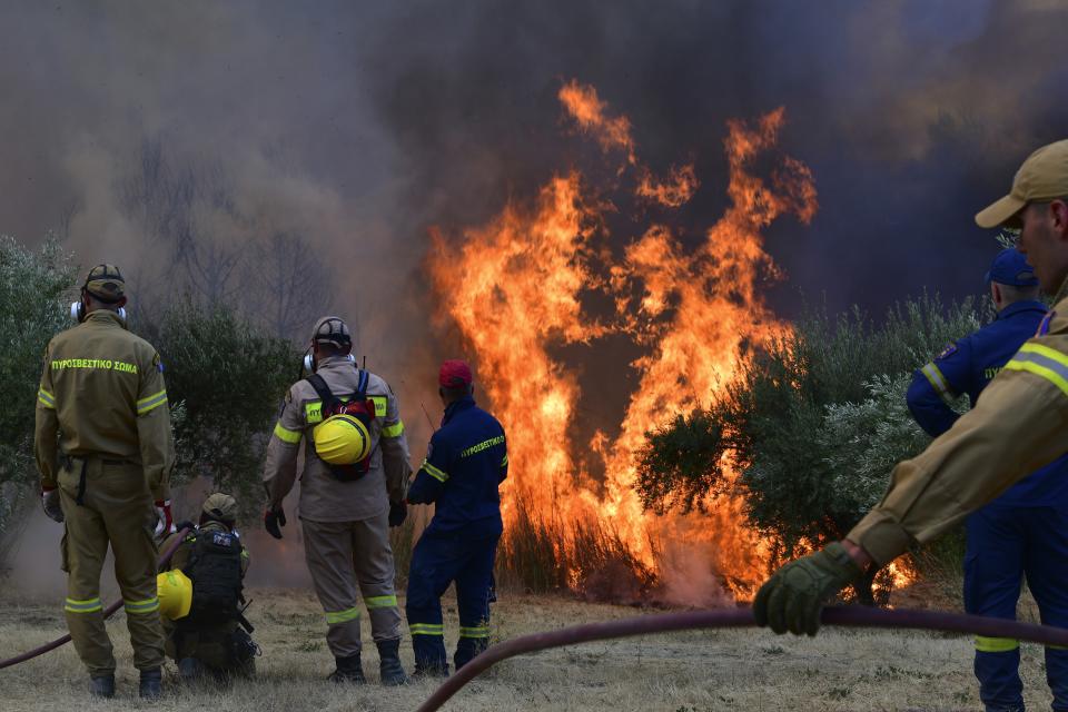 Firefighters try to extinguish a wildfire near Olympia town, western Greece, Thursday, Aug. 5, 2021. Wildfires rekindled outside Athens and forced more evacuations around southern Greece Thursday as weather conditions worsened and firefighters in a round-the-clock battle stopped the flames just outside the birthplace of the ancient Olympics. (Giannis Spyrounis/ilialive.gr via AP)